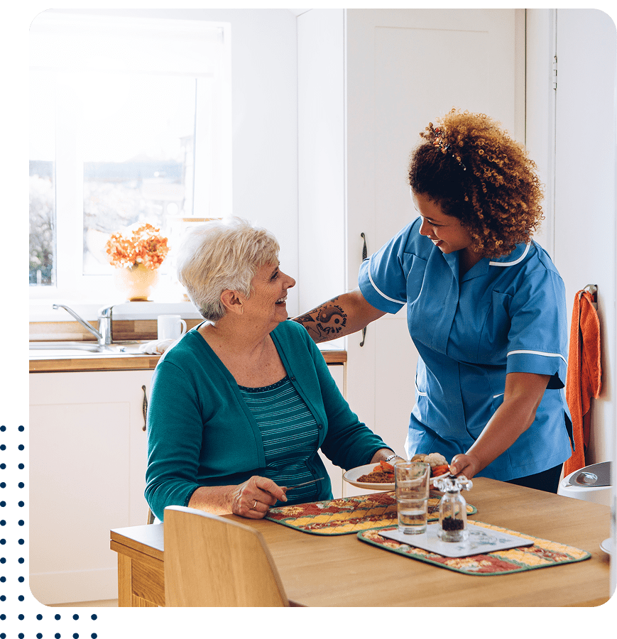 Healthcare worker supporting elderly woman at home